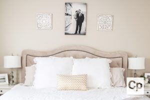 white bedrooms with a bed lamps and artwork